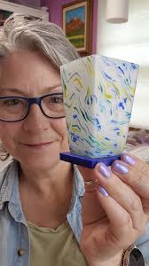 Polymer clay is naturally sticky and so it sticks to glossy surfaces. My  main work surface is tempered glass. I like to use that to my advantage  because it helps keep the