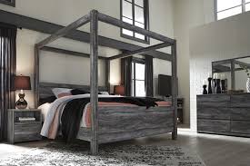 Rest In The Beachy Style Of The Baystorm Canopy Bedroom Set Its Driftwood And Surfer Inspired Smokey Finish Giv Canopy Bedroom Sets Canopy Bedroom Bedroom Set