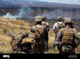 U.S. Marines and Civilians observe the effects of 81mm experimental  non-lethal Indirect Fire Munition (IDFM) rounds during a weapons testing  event, July 16, 2018 at Pohakuloa Training Area, Hawaii. The IDFM is
