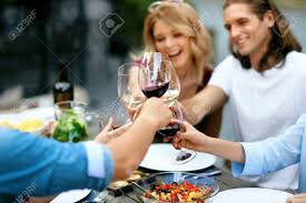 At a cocktail party, one liter of water will serve four guests. People Cheering With Drinks At Outdoor Dinner Party Close Up Of Friends Hands Raising Toast With