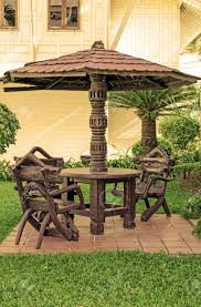 Pacific giftware enchanted garden tree stump table and chairs set mini fairy garden decorative accessory 3pc set. Garden Furniture Chairs And Table Under Wooden Umbrella At Garden Stock Photo Picture And Royalty Free Image Image 23996234