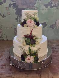 Simple Buttercream Wedding Cake With A Horizontal Line Design Accented With Fresh Flowers A Simple Wedding Cake Tiered Wedding Cake Buttercream Wedding Cake