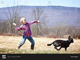 Young Boy Playing Fetch With A Dog Stock Photo Offset