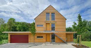 individuell geplantes mehrfamilienhaus modernes mehrfamilienhaus erstling aus credo holzfassade und rotem garagentor ein w zweifamilienhaus haus familien haus