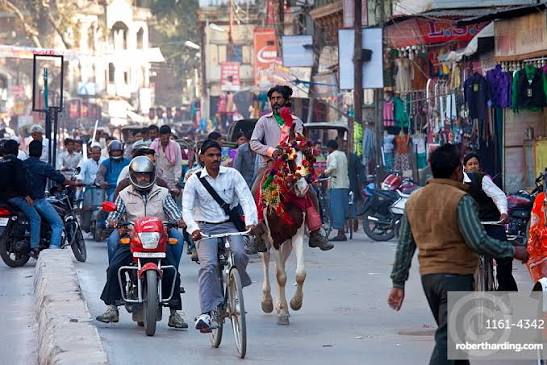 Busy street in Varanasi — traffic, autos and pedestrians all sharing the same narrow road