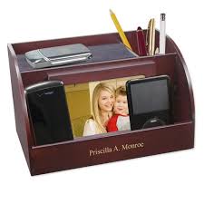 This charging station doubles as a charging dock, allowing users to prop their devices up within the dock. Rosewood Charging Station With Photo Frame And Pencil Cup