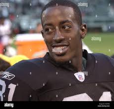 Oakland Raiders defensive back Phillip Adams (28) is tackled by Dallas  Cowboys running back Phillip Tanner (34) and strong safety Eric Frampton  (41) during the third quarter of an NFL preseason football