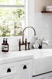 Mounted In White Cabinets Accented With Oil Rubbed Bronze Cup Pulls And A Honed White Marble Counterto Black Kitchen Taps Fish Scale Tile Bronze Kitchen Faucet