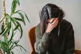 Worried young woman covering face with hand · Free Stock Photo