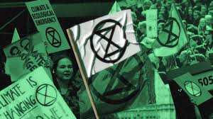 A flag with the extinction rebellion symbol being waved in london, uk. How The Extinction Rebellion Got Its Powerful Logo