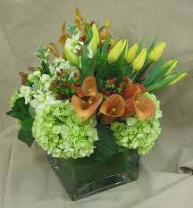 For example, a bud vase is typically a small, minimalist vase that is designed to hold a single flower. This Is A Cube Vase Floral Arrangement That Features Miniature Calla Lilies Hydrangea And Tulips Flower Arrangements Floral Arrangements Yellow Colour Scheme