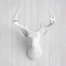 white faux deer head by wall
