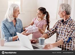 Charming Kid Presenting Box To Her Grandmother Stock Photo