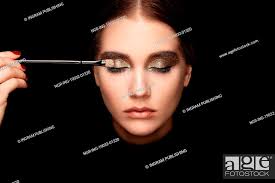 makeup artist applies eye shadow