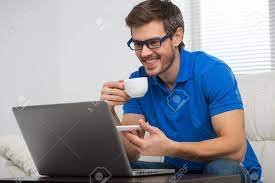 The computer guy provides computer sales and wireless network installations to help you stay connected. Handsome Young Man Working On Computer Laptop At Home Happy Guy Looking At Screen And Holding Cup Stock Photo Picture And Royalty Free Image Image 30867488
