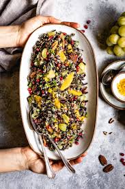cold wild rice salad recipe photographed in the hands of a woman while it is being