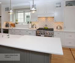 The center island is painted in a warm steel gray color which beautifully contrasts with the surrounding white paneled kitchen cabinets. White Inset Cabinets Gray Kitchen Island Decora