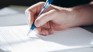 A Person Writing on a Paper · Free Stock Photo