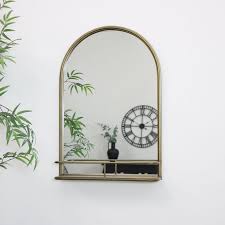 large brass arched mirror with shelf