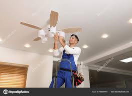 electrician changing light bulb ceiling