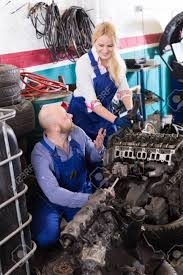 Handsome Smiling Russian Mechanic And Female Assistant Working