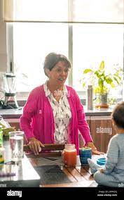 Latin Grandma smiling to her grandson at the kitchen table Stock Photo 