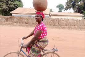 Yambio Woman Rides Bicycle With Pot On