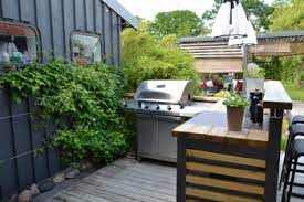 Modern outdoor kitchen featuring a stylish bar setup with an outdoor kitchen featuring a small bar with a modern grill and stove. Outdoor Kitchen Design Ideas For Small Spaces Danielle Fence Outdoor Living