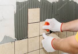 worker putting tiles on the wall in the