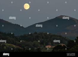 Full Moon September 2022 Basque Country - The Moon rising between the mountains at dusk Stock Photo - Alamy