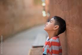 little boy sitting alone with sad