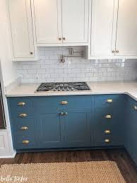 For a bold, warm kitchen, you can paint your cabinets a candy apple red and trim the inlays with black, or paint your entire kitchen in white and then throw in a splash of color by painting the island in the center a vibrant red or black. Blue And White Two Toned Kitchen Cabinets Bella Tucker