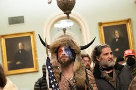 'qanon shaman,' man carrying pelosi's lectern both arrested following capitol riot but there may be an even more blatant sign that angeli is no friend to antifascists: Horned Qanon Shaman Among The Latest People To Be Charged Over The Washington Riot