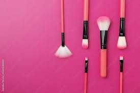 makeup brushes on a pink background