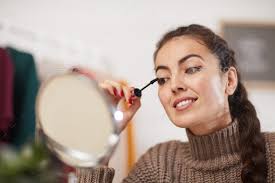 young woman doing makeup stock photo by