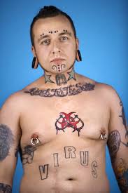 man with tattoos and piercings skin art
