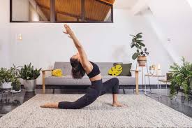 woman practicing yoga pose against sofa