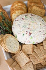 an easy cheeseball is plated with ers and garnished with thyme
