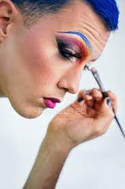 blue hair applying drag makeup