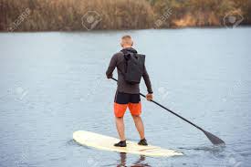 Full Length Portrait Of Man With Backpack Engaged Rowing On The