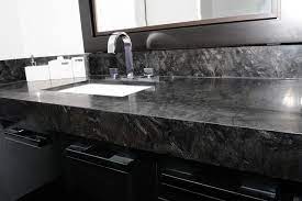 For a crisp, contemporary look, consider pairing nero marquina marble with pale gray cabinetry. Grey Marble Vanity Tops