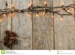 Christmas Lights And Pine Cones On Rustic Wood Stock Photo