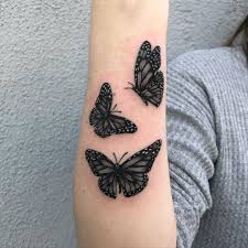 A three colourful butterflies in a row, makes this tattoo bright and positive. Three Gorgeous Black Butterflies Red Ink Tattoos Black Butterfly Tattoo Herb Tattoo