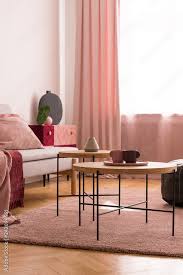 wooden tables on pink carpet in living