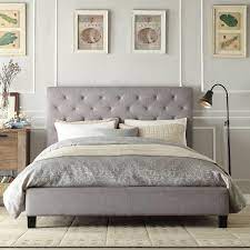 queen on tufted grey upholstered
