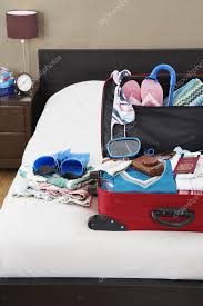 open suitcase on bed stock photo by