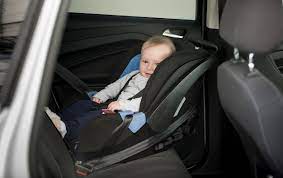 Old Baby Boy Sitting In Child Seat At Car