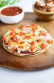 whole taco bell mexican pizza on a pizza stone after being baked and before beings sliced