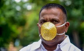 indian man wears gold face mask to ward