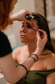 beautician applying makeup to woman